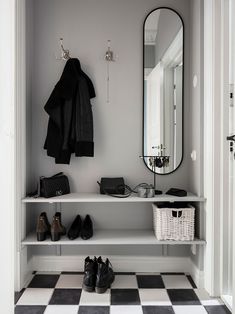 a black and white checkered floor in a room with shoes on the shelf, coat rack, mirror and purse