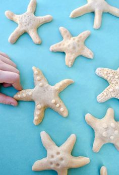 hand reaching for starfish cookies on blue background