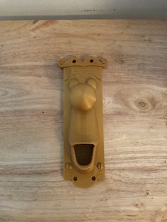 a wooden door handle with a face on it