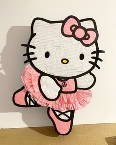 there is a paper cut out of a hello kitty figure on the floor with a pink skirt