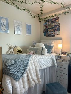 a bedroom with a bed, dresser and pictures hanging on the wall above it's headboard