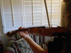 a woman playing the violin in her living room