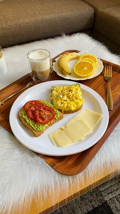 a breakfast tray with eggs, toast and avocado sits on a fur rug