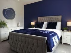 a bedroom with blue walls and white furniture