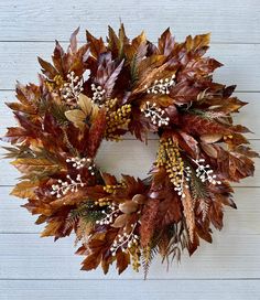 a wreath made out of leaves and berries on a white wooden background with text overlay that reads diy fall wreath