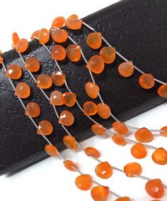 an orange necklace is laying on top of a black case