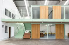 the inside of a building with wooden doors and green stairs leading up to two levels