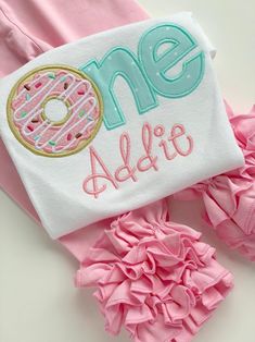 a pink and blue outfit with a donut on the front that says one, addie