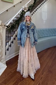 Get ready for some holiday outfit inspo! Create this casual look by pairing a beautiful cream tulle maxi skirt from Anthropologie with a cute sweater, a trendy oversized denim jacket, and aesthetic Western boots. Accessorize with chunky jewelry, vintage broaches, and a cozy beanie for a cool vibe. Perfect for everyday wear and festive occasions – this comfy look has got you covered. Tulle Maxi Skirt Outfit | Anthropologie Holiday Outfit | Holiday Outfit Ideas | Hunter Premo Tulle Maxi Skirt Outfit, Oversized Outfit Aesthetic, Aesthetic Western, Anthropologie Holiday, Cozy Beanie, Outfit Holiday, Tulle Maxi Skirt, Oversized Outfit