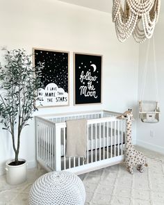 a baby's room with two posters on the wall and a white crib