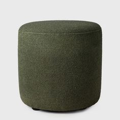 a large round ottoman in green fabric