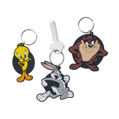 three cartoon key chains with bugs and goofy characters on them, one in the shape of an egg