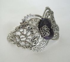 "This beautiful silver plated filigree cuff bracelet has a silver plated triple moon design, amethyst setting with silver plated embellishments and silver plated chain. 6\" long adjustable to 9\" long. Silver plated lobster clasp." Mystical Jewelry Bracelet Gift, Handmade Gothic Metal Bracelets, Adjustable Mystical Silver Bracelet, Adjustable Silver Mystical Bracelet, Gothic Bangle Bracelet For Gift, Spiritual Silver Decorative Jewelry, Spiritual Decorative Silver Jewelry, Spiritual Silver Amethyst Bracelets, Handmade Spiritual Silver Cuff Bracelet