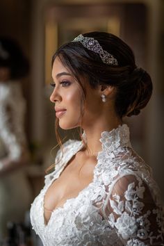 a woman wearing a tiara standing in front of a mirror and looking into the distance