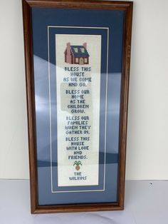 a framed cross stitch sample with the words, please this is us come to our home