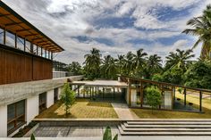 an aerial view of a modern house surrounded by palm trees