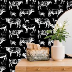 a black and white cow wallpaper next to a mirror with a plant on it