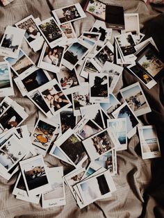 many polaroid photos are scattered on a bed