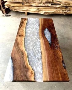 a table made out of wood and glass in the middle of some concrete flooring