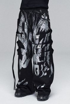 The Multi-Layered Striped Graffiti Cargo Pants are an exceptional piece, embodying a wild and expansive style. These wide-leg pants are adorned with a graffiti-style paintbrush effect throughout, creating a vibrant and artistic appearance. The intricate design is further enhanced by meticulous spliced and strap detailing, adding depth and a tactile dimension to the garment. An elastic waistband ensures a comfortable and adjustable fit, making these pants suitable for a variety of body types. The Skelatin Pants, Cheap Trendy Acid Wash Bottoms, Luxury Trendy Bottoms For Streetwear, Cheap Rave Style Party Bottoms, Luxury Trendy Pants For Streetwear, Cheap Ripped Bottoms For Streetwear, Luxury Modern Bottoms For Streetwear, Luxury Distressed Pants For Streetwear, Luxury Mid-rise Pants For Streetwear