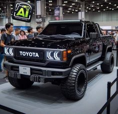 a black truck is on display at an auto show