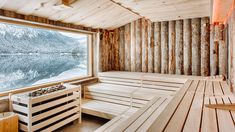 an indoor sauna with wooden flooring and windows looking out onto the mountains outside