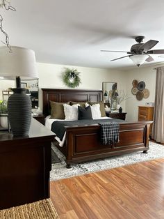 a bedroom with a bed, dresser and ceiling fan in the middle of the room