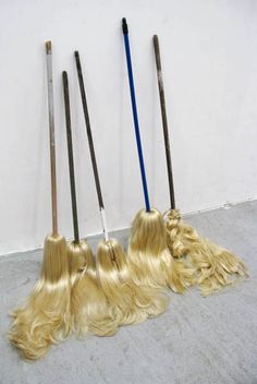 three brooms with long blonde hair on the floor