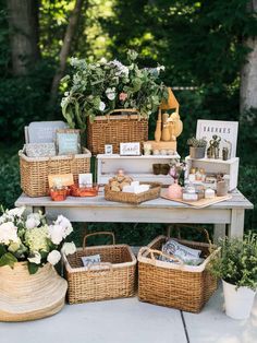 a table topped with baskets filled with flowers and books on top of a wooden bench