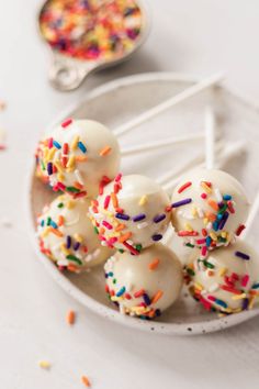 white cake pops with sprinkles on a plate