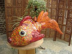 a fish shaped planter sitting on top of a wooden table