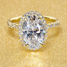 an oval cut diamond surrounded by diamonds on a gold background