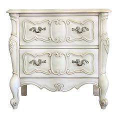 a white dresser with ornate carvings on the top and bottom drawers, against a white background