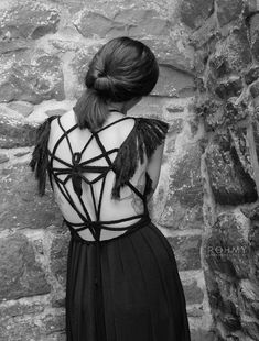 a woman standing in front of a brick wall with her back turned to the camera