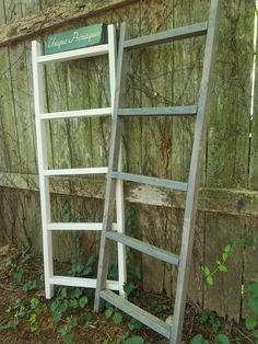 two ladders leaning against a wall in front of a sign