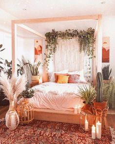 a bed with plants and candles on top of it in a room filled with potted plants