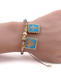 a woman's hand with two bracelets on it and one is wearing a beaded bracelet