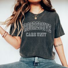 a woman with long hair wearing a black t - shirt that says progressive care unit