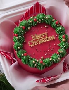 someone is holding a christmas wreath shaped cake