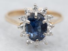 Beautiful, classic, and timeless, this vintage ring is the perfect setting for the deep, royal blue Ceylon sapphire we've set at the center. Purchased on one of our frequent buying trips to Sri Lanka, or old Ceylon, this pretty sapphire has outstanding flash and glitter. The halo style is pretty, both framing and protecting the stone with the protective multi-prong setting surrounding the sapphire and multiple prongs encasing the diamonds. Perfect for a cocktail ring, this is also perfectly sized to be worn day to day, with an office wardrobe or casual wear.Metal: 14K White and Yellow Gold Gem: Sapphire 1.02 Carats Gem Measurements: 6.8 x 5.3 mm, OvalAccents: 12 Diamonds totaling .18 Carats, F in Color, SI1 in Clarity Ring Size: 5.50Marks: "HDS 14K" Stamped on the inside band Luxury Classic Sapphire Ring With Halo Setting, Square Cut Sapphire Jewelry With Halo Setting, 14k Gold Sapphire Halo Jewelry, Elegant 14k Gold Sapphire Halo Ring, Luxury Classic Halo Ring With Lab-created Sapphire, Yellow Gold Sapphire Ring, Sapphire Anniversary, Office Wardrobe, Gold Sapphire Ring