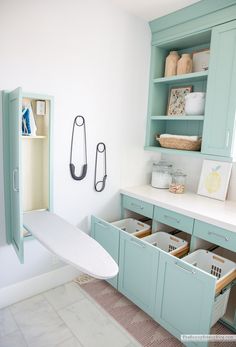 a white surfboard sitting on top of a wooden cabinet in a room with blue cabinets