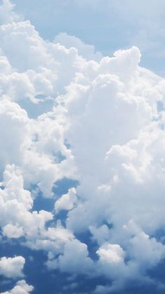 an airplane is flying high in the sky with fluffy white clouds above it and below