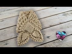 two knitted mittens sitting on top of a wooden table next to a pair of slippers