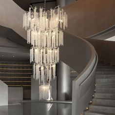 a large chandelier hanging from the ceiling in a room with grey walls and stairs