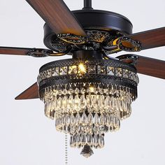 a chandelier hanging from a ceiling fan with crystal drops on the light fixture