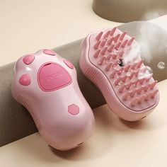 two pink hairbrushes sitting next to each other on top of a white counter