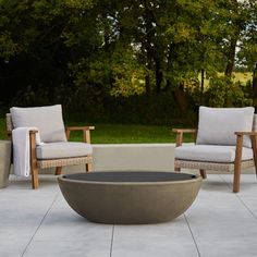 an outdoor seating area with two chairs and a fire pit in the middle of it