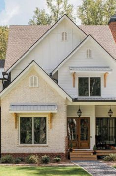 a large white house with lots of windows on it's front porch and landscaping