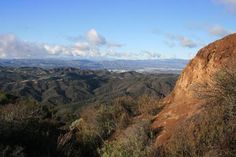 a view of the mountains and valleys from a high point on a mountaintop with clouds in the sky