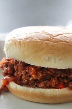 a sloppy joe sandwich sitting on top of a white plate